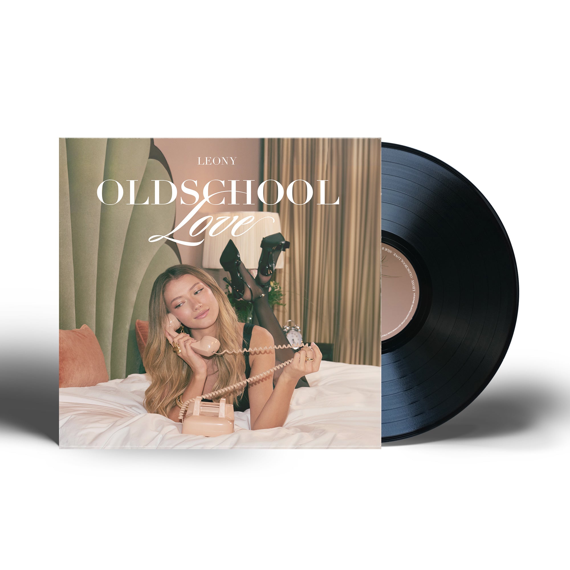 Schallplatte des Albums „Oldschool Love“ von LEONY: Cover zeigt Leony auf einem Bett liegend, mit Retro-Telefon in der Hand, verträumter Blick zur Seite, im Hintergrund grüne Wandverkleidung, altrosa Kissen und Vorhänge. Die schwarze Vinyl ragt rechts halb sichtbar hinter dem quadratischen Cover hervor.